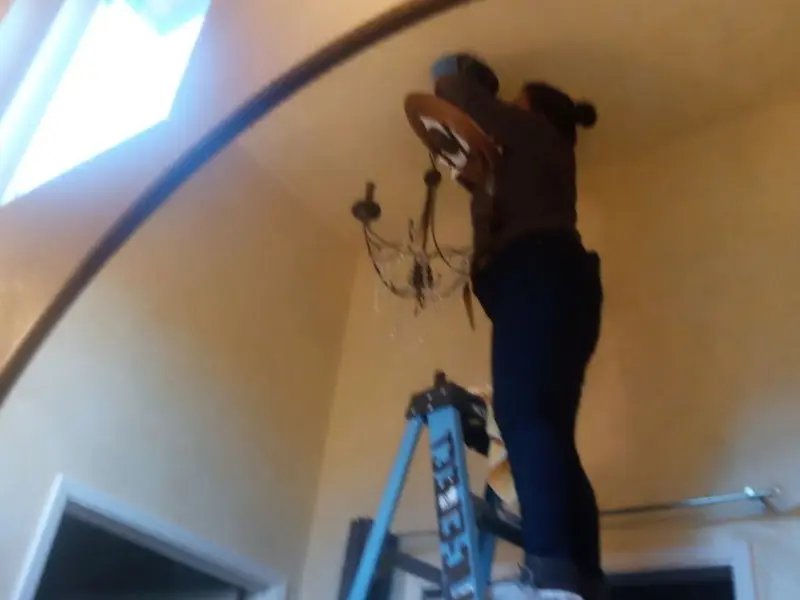 Electrician installing a chandelier in a Emeryville residence